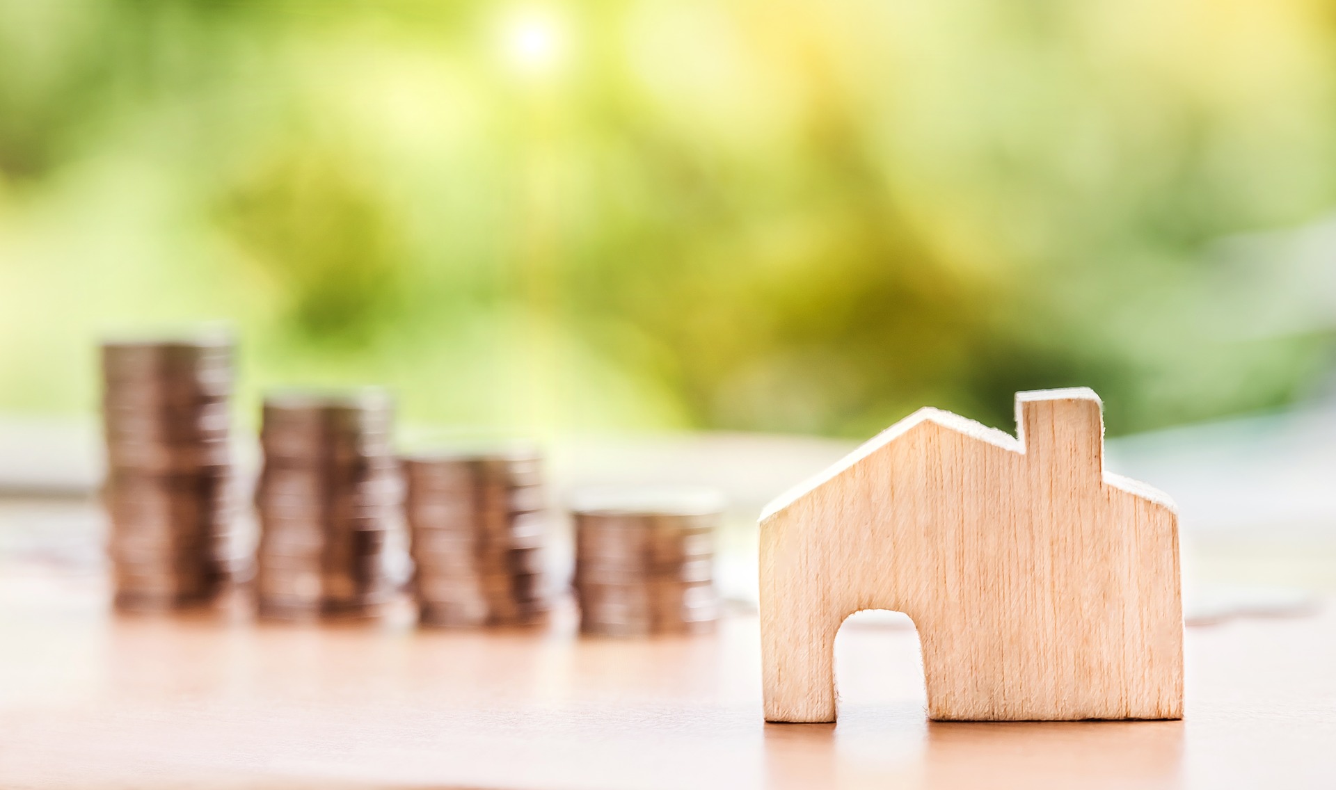 Image of stacks of coins with a wooden house